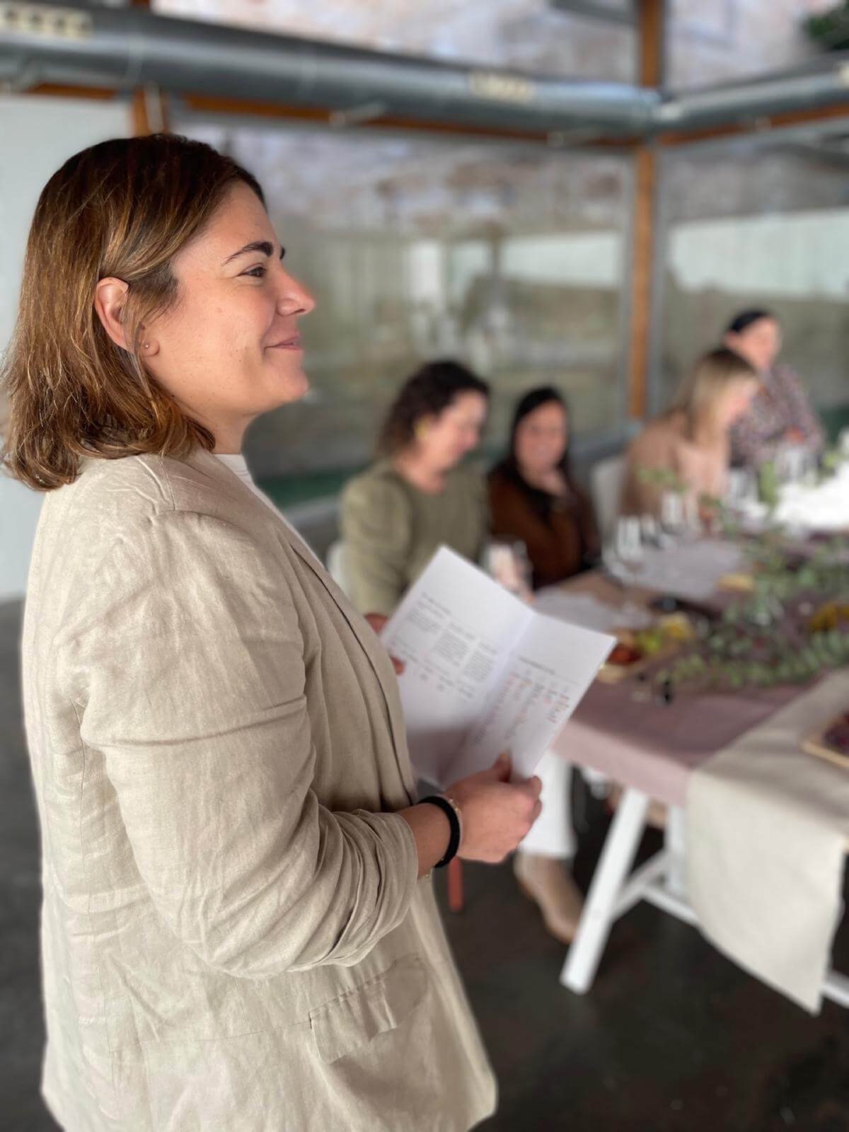 María presentando una cata de vino a un grupo